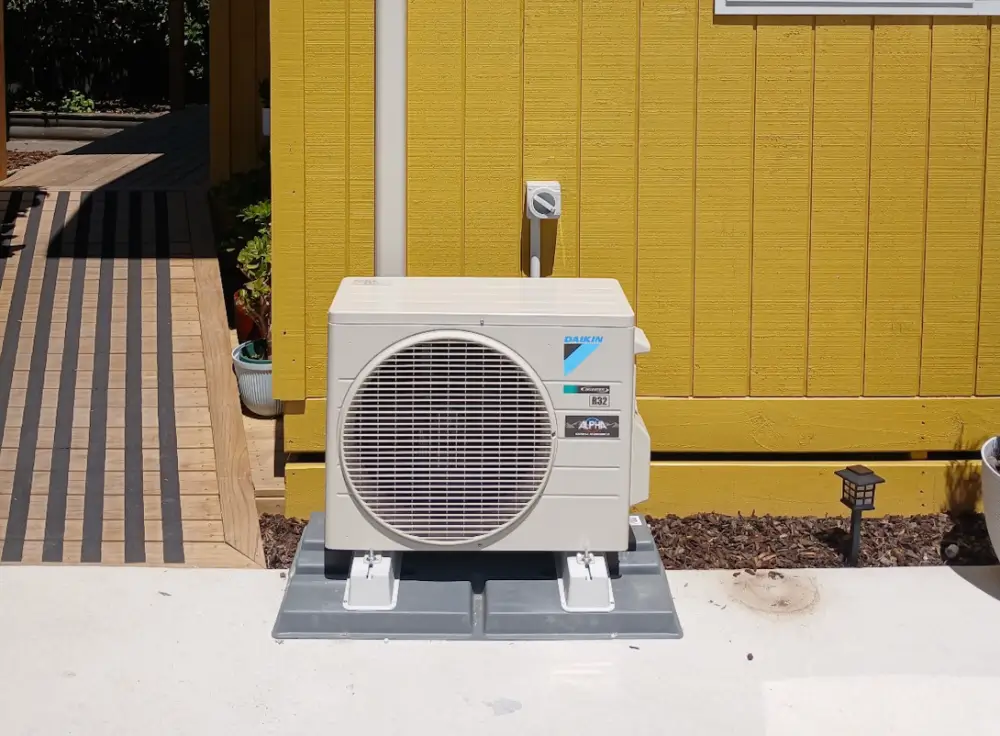 Outdoor HVAC condenser inspected for a refrigerant leak